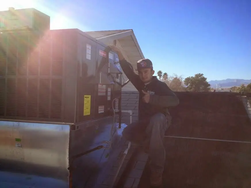 HVAC technician performing HVAC Inspection on a rooftop unit in Stratford